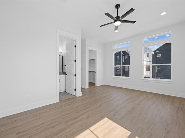 unfurnished living room with recessed lighting, wood finished floors, a ceiling fan, and baseboards