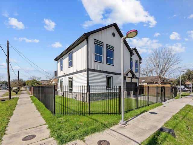 view of property exterior with a fenced front yard and a yard