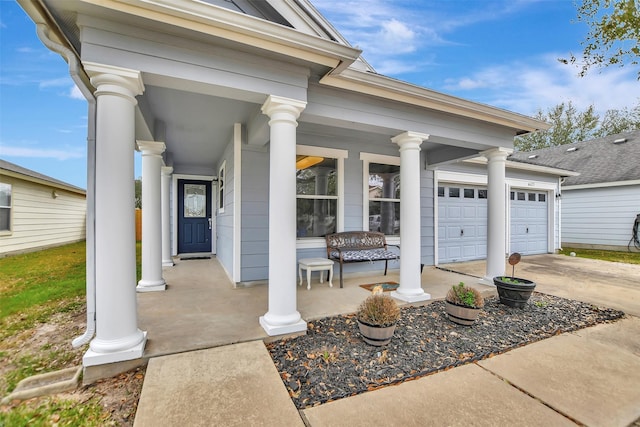 doorway to property with driveway, covered porch, and an attached garage