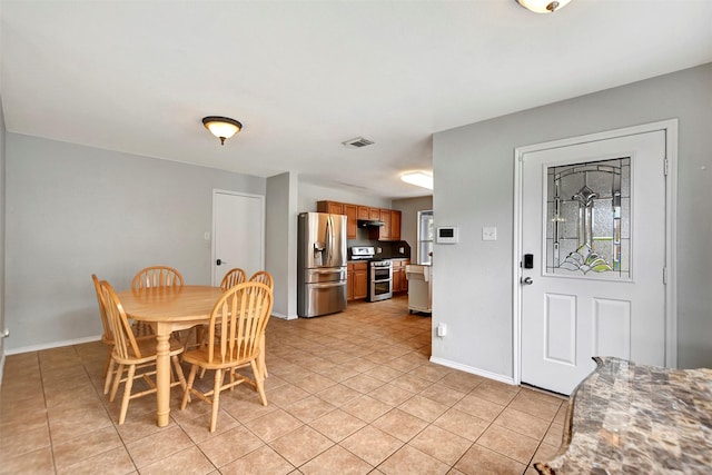 dining space with light tile patterned flooring, visible vents, and baseboards