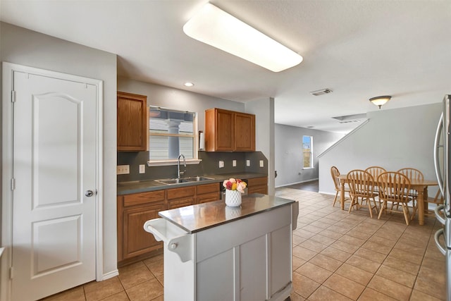 kitchen with a wealth of natural light, dark countertops, a sink, and visible vents