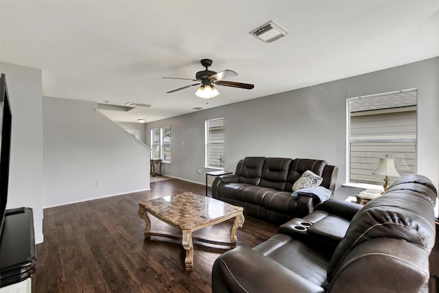 living area featuring a ceiling fan, visible vents, baseboards, and wood finished floors