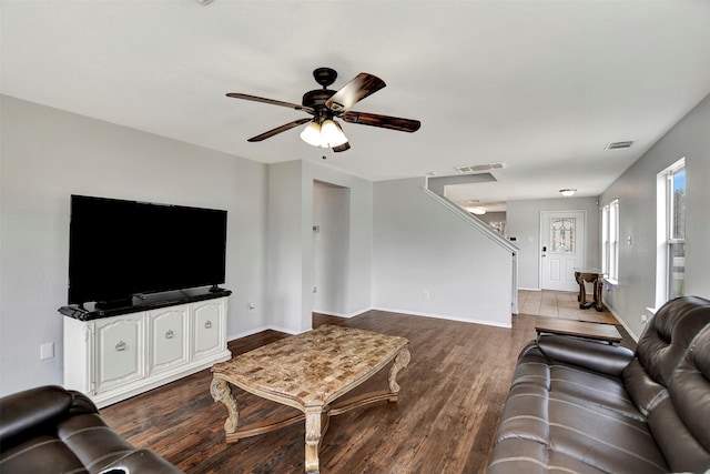 living area with baseboards, ceiling fan, visible vents, and wood finished floors