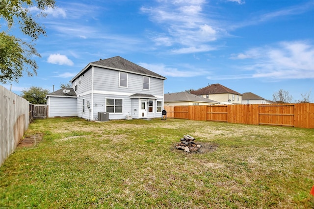 back of property with a yard, cooling unit, and a fenced backyard