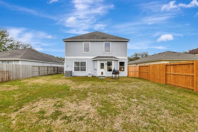 back of house featuring a lawn, cooling unit, and a fenced backyard