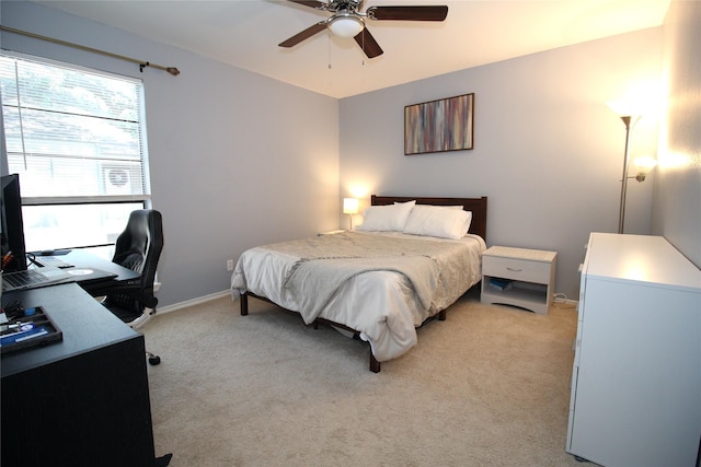 bedroom with a ceiling fan, light colored carpet, and baseboards