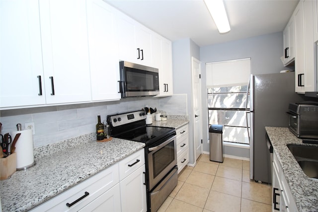 kitchen featuring white cabinetry, stainless steel appliances, and decorative backsplash