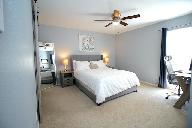 bedroom with a ceiling fan, light colored carpet, and baseboards