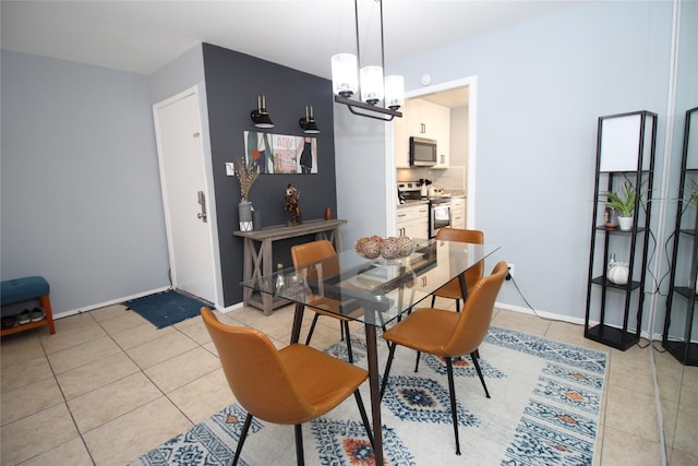 dining room with light tile patterned flooring, a notable chandelier, and baseboards