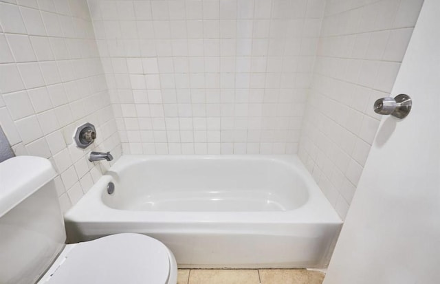 full bathroom featuring toilet, a bathing tub, and tile patterned flooring