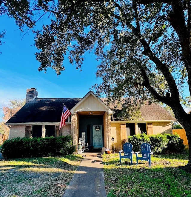 ranch-style home with a front yard, a chimney, and fence
