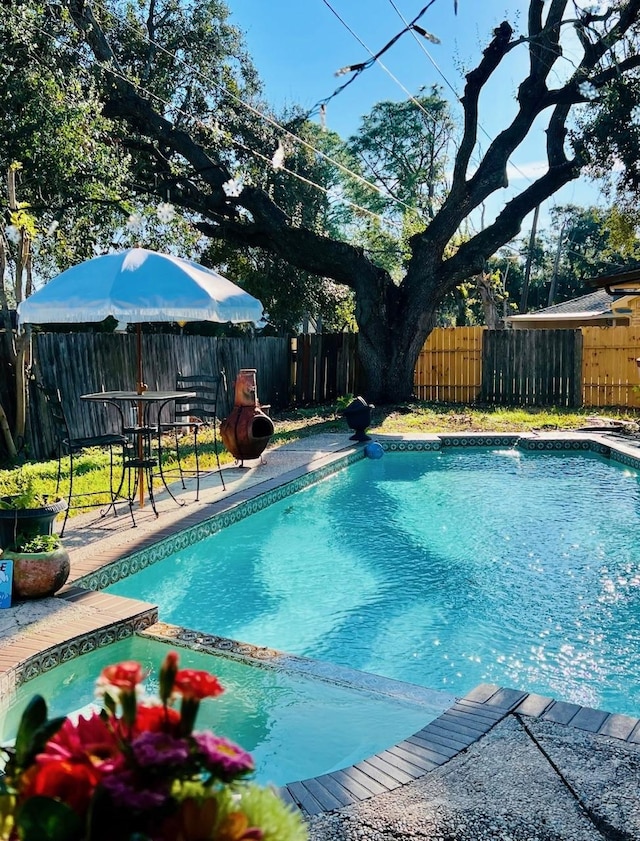 view of swimming pool featuring a patio area, a fenced backyard, and a pool with connected hot tub