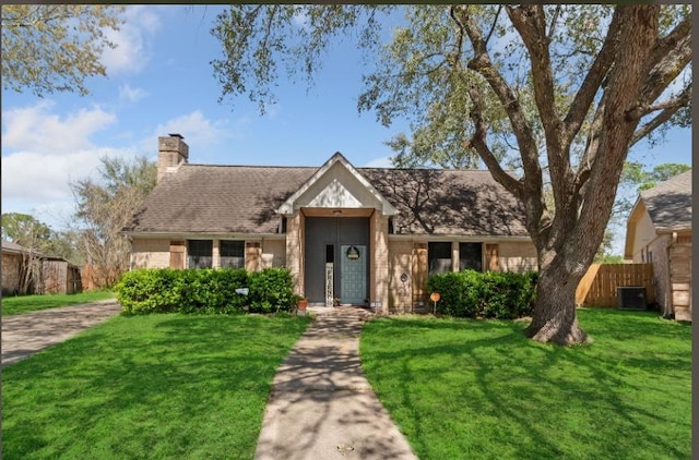 single story home with a front yard, central AC, and fence