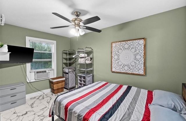 bedroom with ceiling fan, marble finish floor, cooling unit, and baseboards