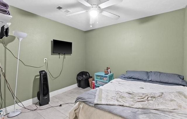 bedroom featuring ceiling fan, light tile patterned floors, visible vents, and baseboards