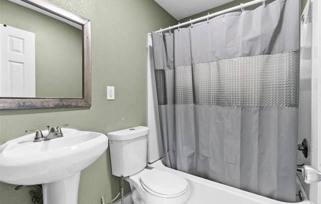 full bath featuring toilet, a sink, and shower / bath combination with curtain