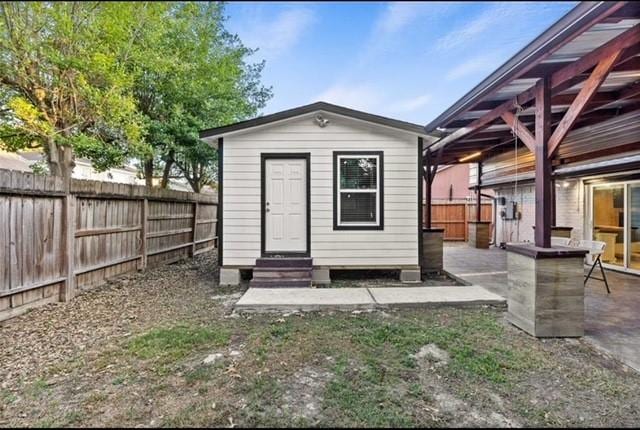 view of outbuilding with entry steps, a fenced backyard, and an outbuilding