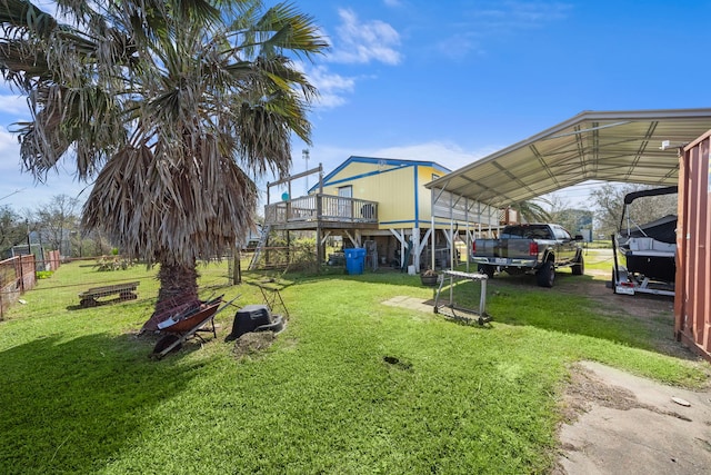 view of yard featuring driveway, fence, and a detached carport