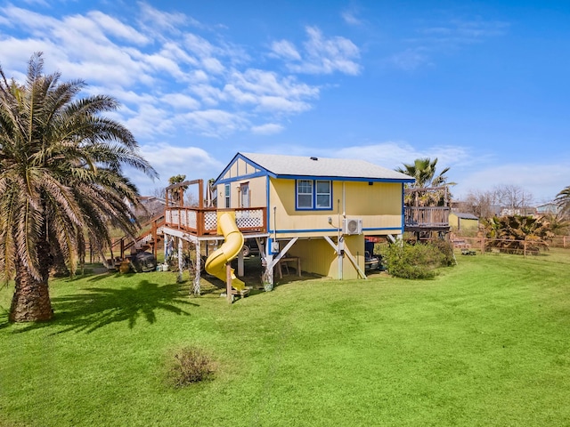 rear view of house featuring a lawn and a playground