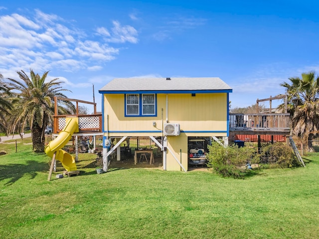 back of house with ac unit, a playground, a yard, a shingled roof, and a deck