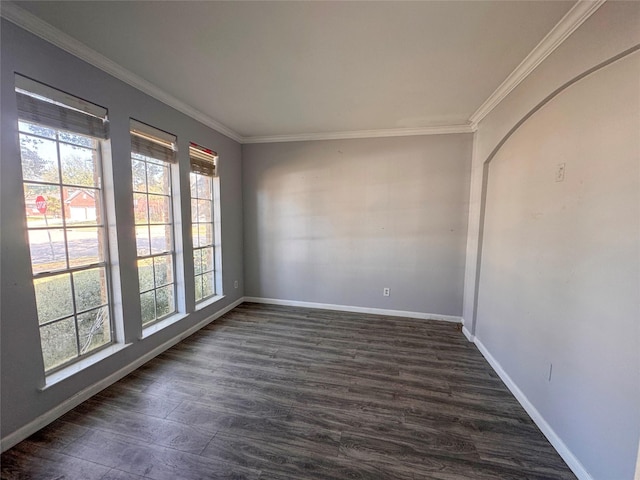 empty room with crown molding, baseboards, and dark wood-type flooring