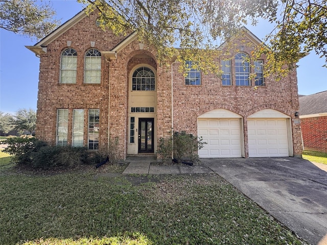 view of front of house with driveway, brick siding, and french doors