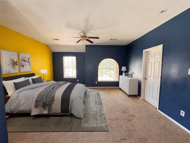 carpeted bedroom featuring a ceiling fan, visible vents, and baseboards