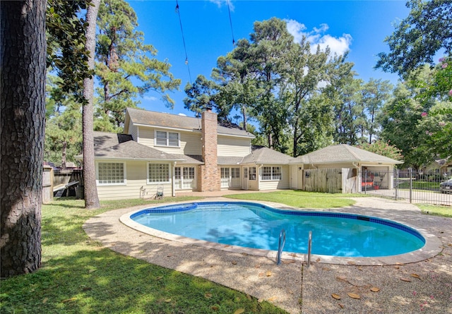 view of swimming pool with a lawn, fence, and a fenced in pool