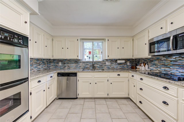 kitchen featuring light tile patterned floors, decorative backsplash, appliances with stainless steel finishes, light stone countertops, and a sink