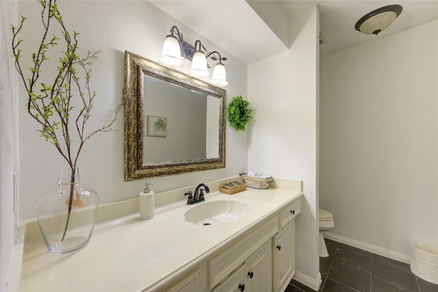 bathroom with toilet, baseboards, and vanity