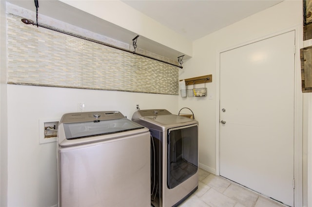 washroom with washer and dryer, laundry area, and light tile patterned flooring