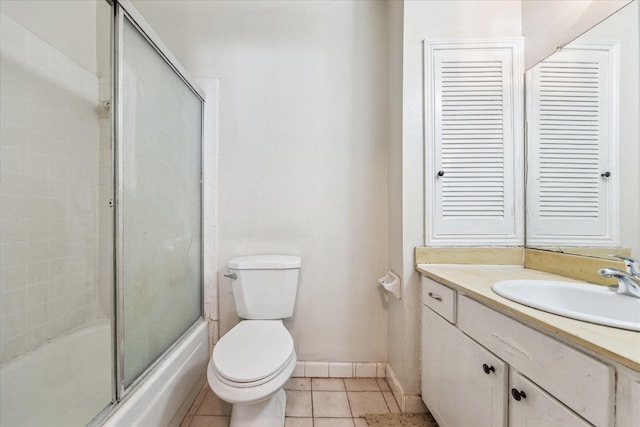 full bathroom with tile patterned floors, toilet, shower / bath combination with glass door, baseboards, and vanity