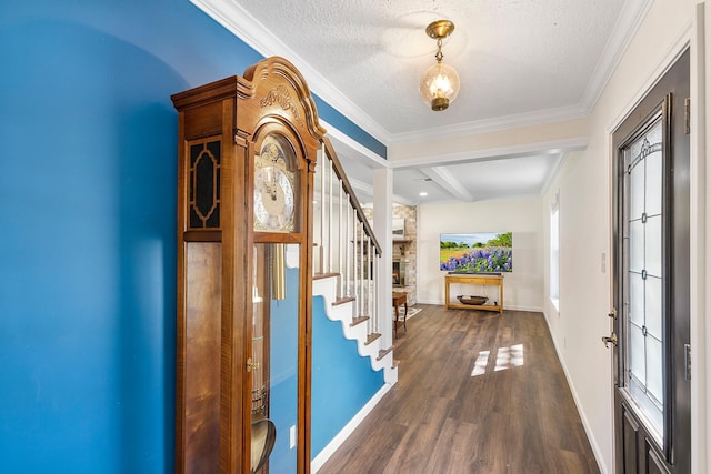 foyer with a textured ceiling, dark wood-style floors, crown molding, baseboards, and stairs