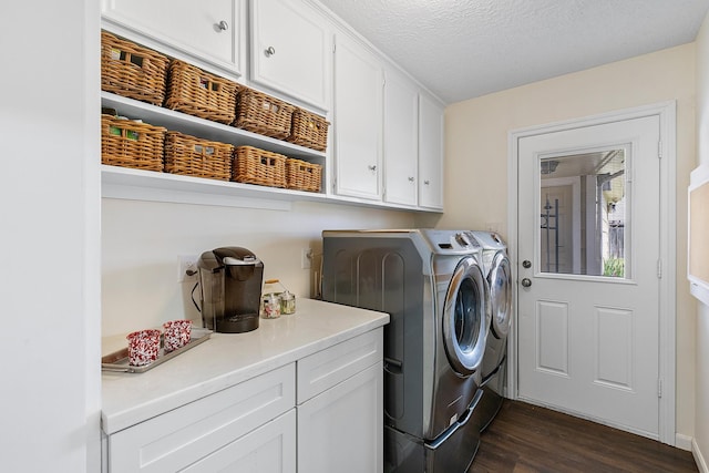 washroom with washing machine and dryer, cabinet space, a textured ceiling, and dark wood-style flooring