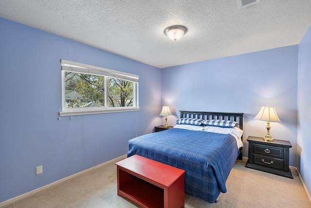 bedroom with baseboards, carpet floors, a textured ceiling, and visible vents