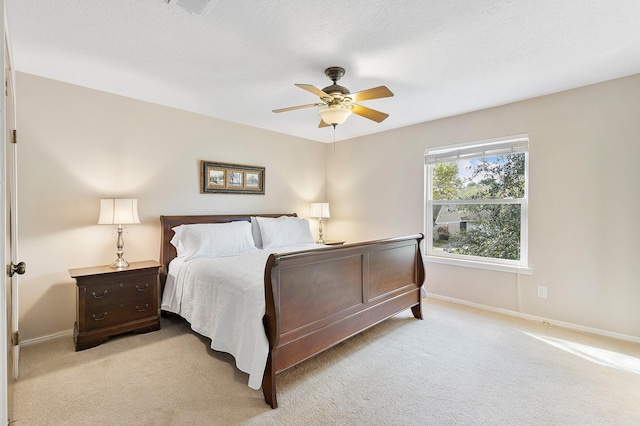 bedroom with a ceiling fan, baseboards, and light carpet