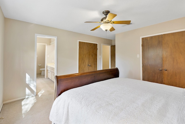 bedroom featuring visible vents, light carpet, a closet, ensuite bath, and a ceiling fan