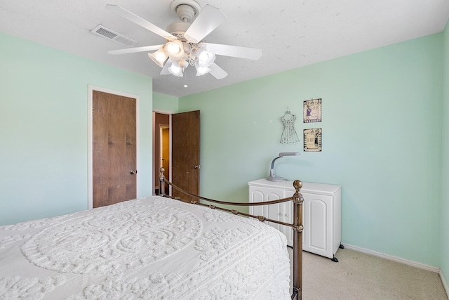 bedroom with visible vents, light colored carpet, baseboards, and ceiling fan