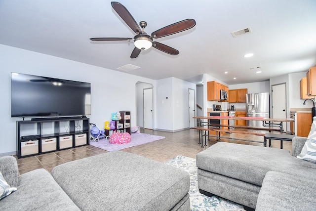 tiled living area with a ceiling fan, recessed lighting, visible vents, and baseboards