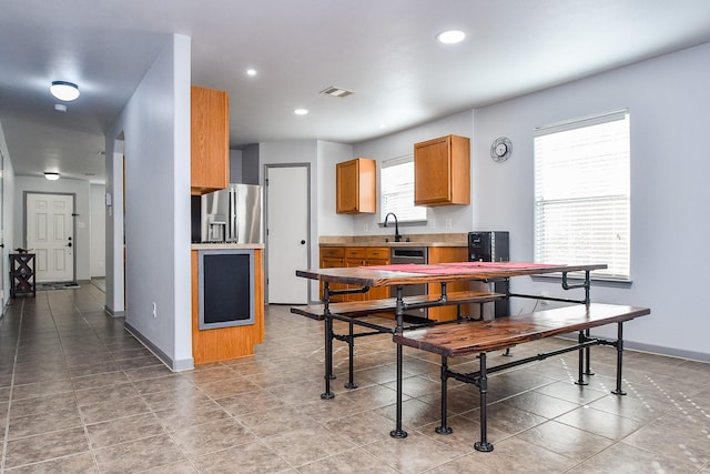 kitchen with stainless steel fridge, visible vents, light countertops, and baseboards