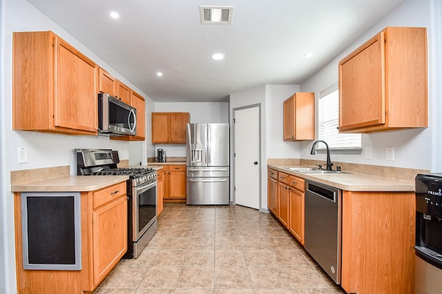 kitchen featuring light tile patterned floors, visible vents, appliances with stainless steel finishes, light countertops, and a sink