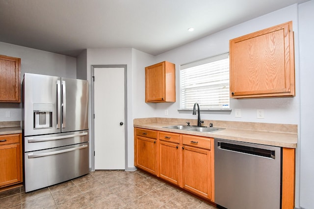 kitchen with stainless steel appliances, a sink, and light countertops