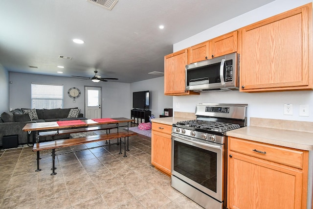 kitchen with visible vents, appliances with stainless steel finishes, open floor plan, and light countertops