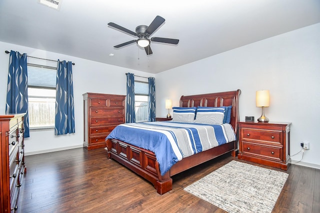 bedroom featuring a ceiling fan, multiple windows, visible vents, and wood finished floors