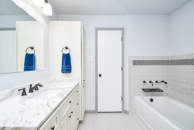 full bathroom featuring a tub to relax in, vanity, and tile patterned floors