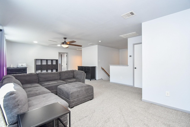 living area featuring carpet floors, visible vents, ceiling fan, and baseboards