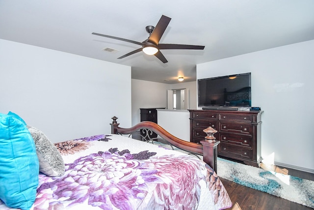 bedroom featuring a ceiling fan, visible vents, and wood finished floors