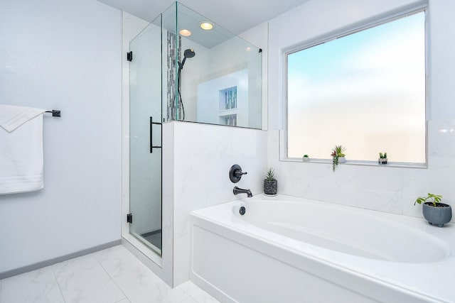 bathroom featuring marble finish floor, a stall shower, a bath, and baseboards