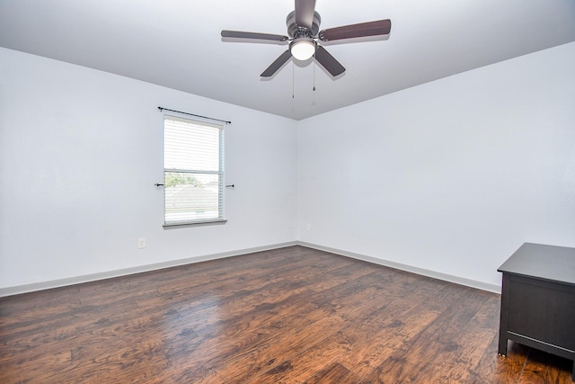 unfurnished room with a ceiling fan, dark wood-style flooring, and baseboards