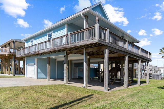 rear view of property featuring concrete driveway, a lawn, and a wooden deck